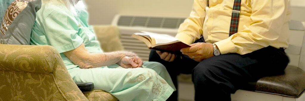 Elderly woman sitting listening to gospel study with caregiver